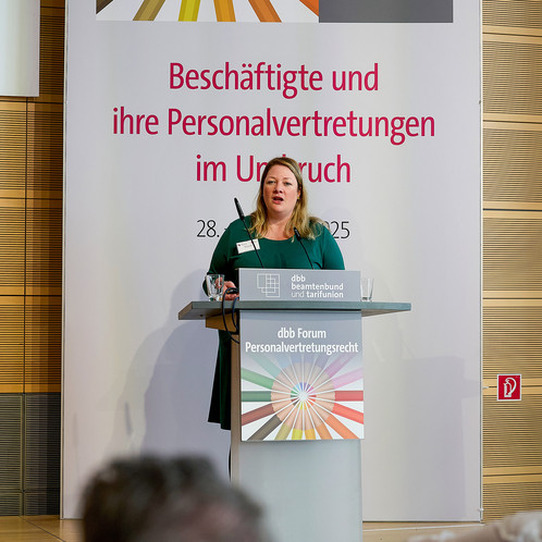 Eine Frau steht hinter einem Rednerpult