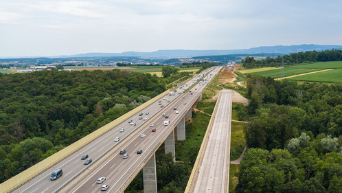 Aerial view of a German Autobahn with construction works for a new railway bridge besides. Drone photo taken at Denkendorf near Stuttgart - on a weekend, hence not much truck traffic.
