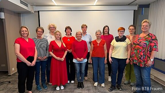 Eine Gruppe Frauen in formaler Kleidung blickt in die Kamera