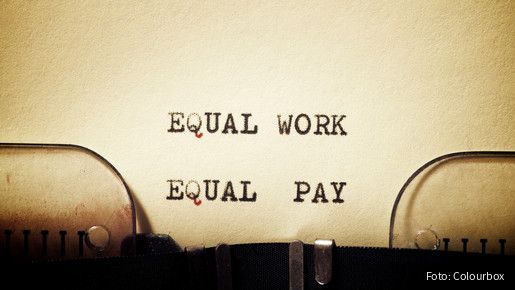 Auf einem in eine Schreibmaschine eingespannten Blatt stehen die getippten Worte "Equal Work - Equal Pay"