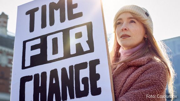 Weltfrauentag dbb jugend Eine junge Frau hält bei einer Demonstration ein Plakat mit der Aufschrift "Time for Change" hoch.