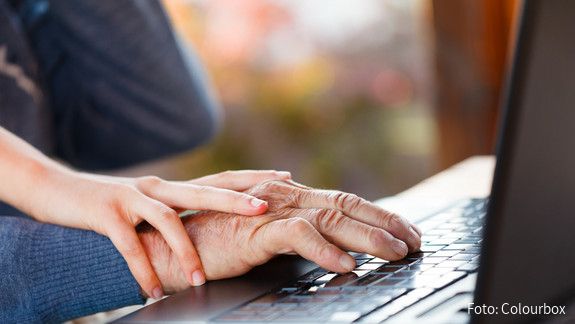 Internationaler Tag der älteren Menschen am 1. Oktober: Senioren sind nicht „von gestern“ Die Hand einer älteren Person liegt auf dem Mauspad eines Laptops. Auf der Hand liegt die eine jüngeren Person.