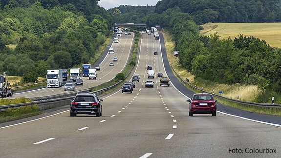 Das Foto zeigt Autos von hinten auf einer dreispurigen Autobahn.