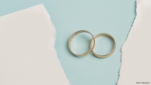 Das Foto zeigt zwei Eheringe, die übereinander liegen. 