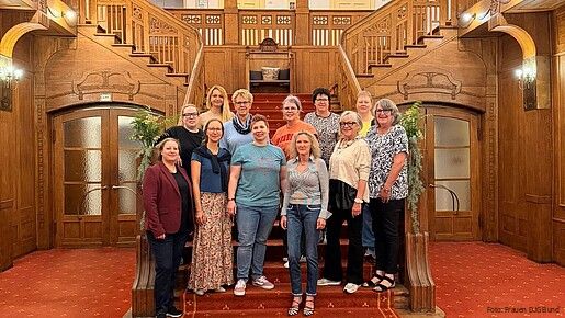 Gruppenfoto: Frauen stehe auf einer Treppe und blicken in die Kamera