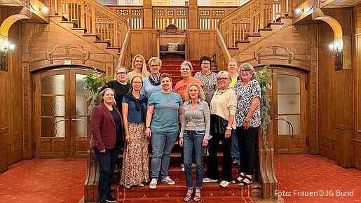 Gruppenfoto: Frauen stehe auf einer Treppe und blicken in die Kamera