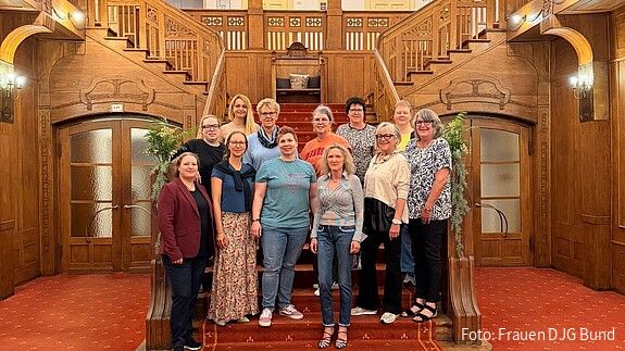 Gruppenfoto: Frauen stehe auf einer Treppe und blicken in die Kamera