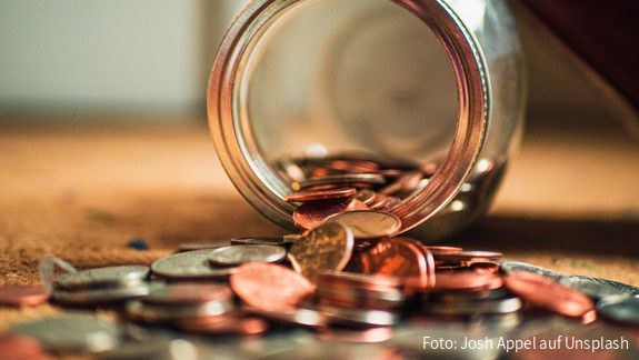 Geldmünzen Geldmünzen fallen aus einem Glas