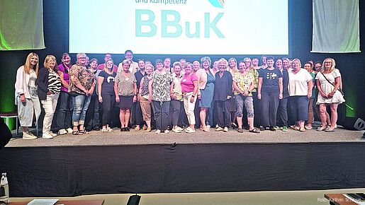 Eine Gruppe Frauen steht auf einer Bühne in einer Konferenzhalle
