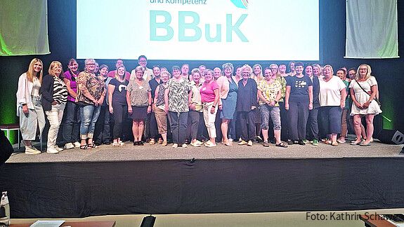 Eine Gruppe Frauen steht auf einer Bühne in einer Konferenzhalle
