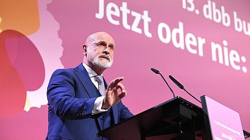 Ein Mann steht hinter einem Rednerpult und spricht in das Mikrofon