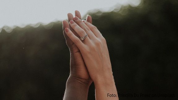 Hände unterschiedlicher Hautfarben halten einander