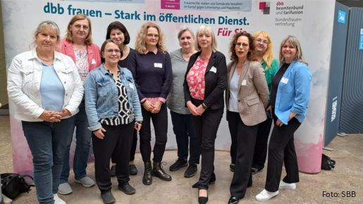 Eine Gruppe Frauen steht vor einem grauen Aufsteller