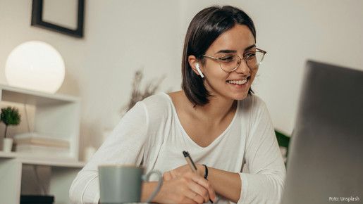 Das Foto zeigt eine Frau, die im Homeoffice ist und gerade an einer Videokonferenz teilnimmt.