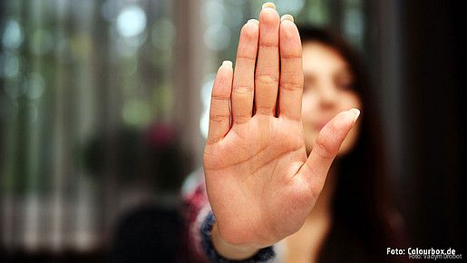 Frau hält Hand abwehrend