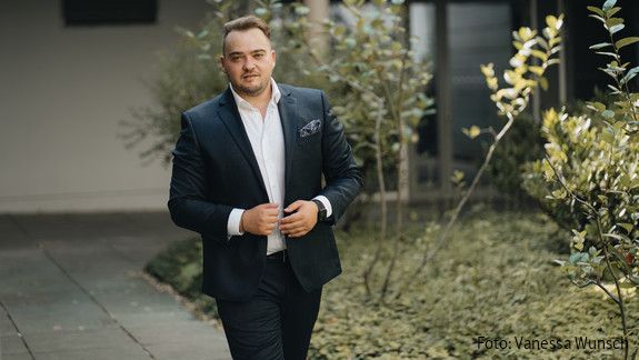 dbb jugend zum Tag der Deutschen Einheit Matthäus Fandrejewski, Vorsitzender der dbb jugend, steht in einem begrünten Innenhof.