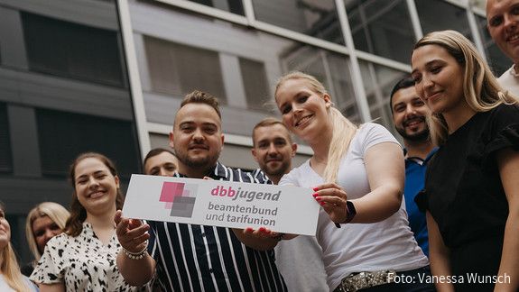START-Broschüre - dbb jugend Zu sehen sind Mitglieder der dbb jugend mit einem Schild, auf dem "dbb jugend" steht.