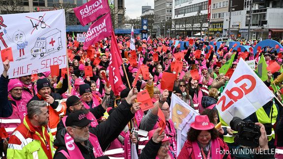 Eine Menschenmenge in bunten Warnwesten und Fahnen