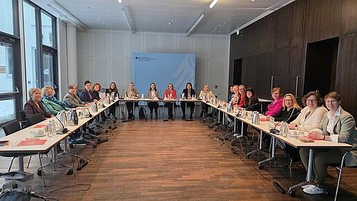 Eine Gruppe Frauen sitzt an Tischen in einem Seminarraum