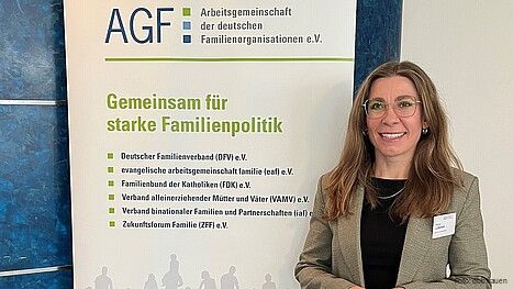 Eine Frau steht vor einem bunten Aufsteller