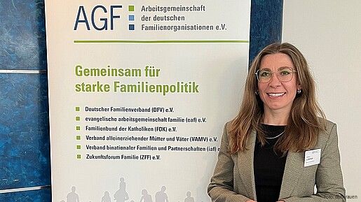 Eine Frau steht vor einem bunten Aufsteller