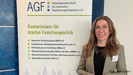 Eine Frau steht vor einem bunten Aufsteller