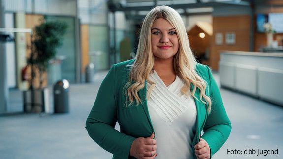 Foto einer Frau mit blonden Haaren und grüner Jacke