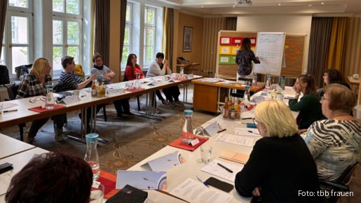 Eine Gruppe Frauen sitzt in einem Seminarraum im Tischkreis