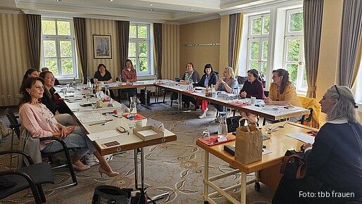 Blick in einen Seminarraum, viele Frauen sitzen an den Tischen und diskutieren